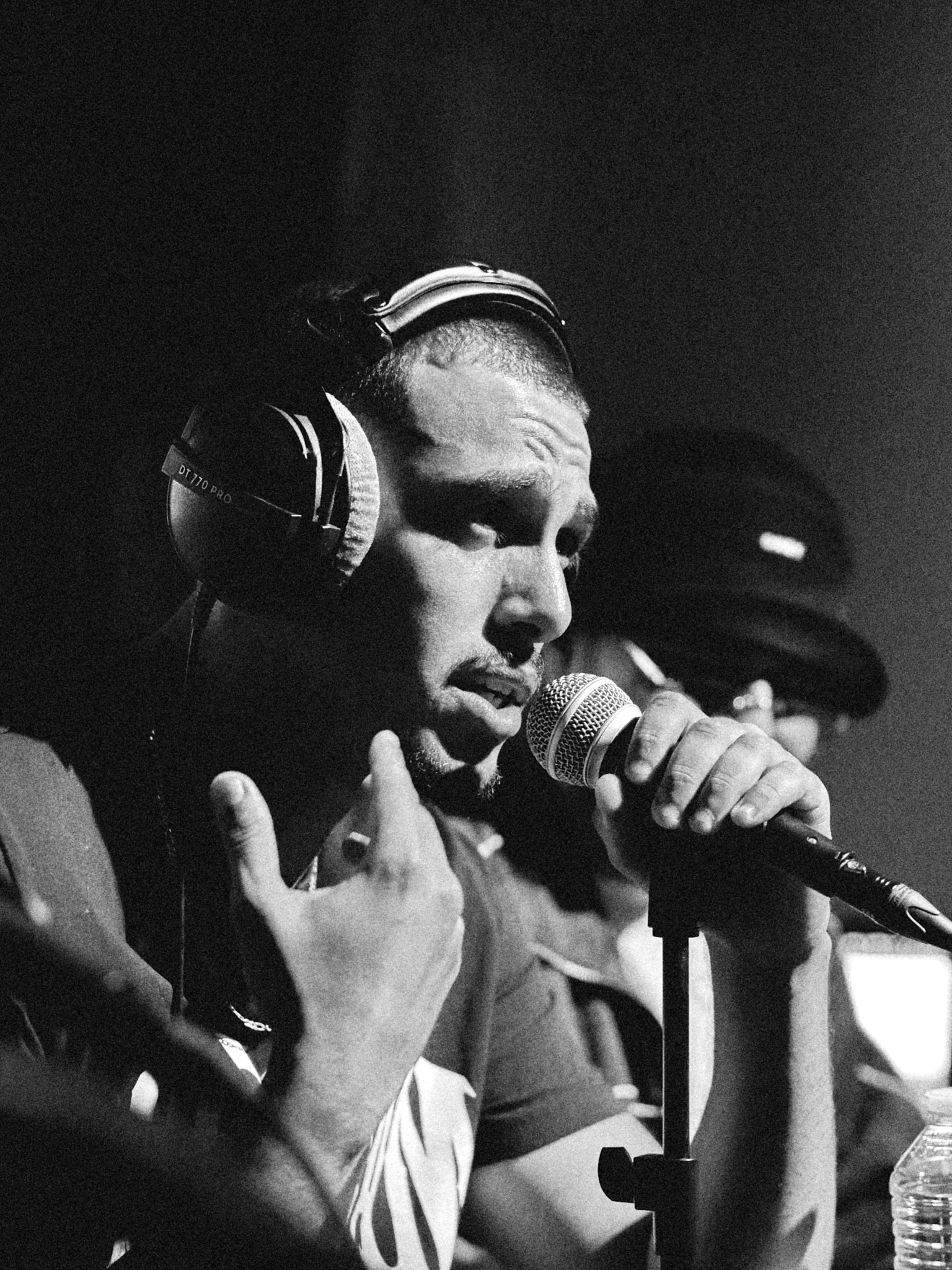 Rappeur au casque audio et au micro, regard concentré, battle de freestyle, noir et blanc